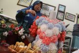 Seorang kader lingkungan membuat souvenir dan produk kerajinan lainnya dengan menggunakan sampah popok bayi untuk selanjutnya dijual dengan harga Rp5.000 hingga 150 ribu rupiah di Tunjungsekar, Malang, Jawa Timur, Selasa (3/10). Selain untuk menambah pendapatan masyarakat, pemanfaatan sampah popok bayi menjadi kerajinan tersebut dilakukan untuk mendukung upaya pengurangan pencemaran di kawasan aliran sungai DAS Brantas yang menurut Lembaga Kajian Ekologi dan Konservasi lahan Basah (Ecoton) didominasi sampah popok bayi yang jumlahnya mencapai tiga juta per hari. Antara Jatim/Ari Bowo Sucipto/mas/17.