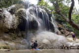 Pengunjung mandi di bawah air terjun Bidadari yang berada satu kawasan dengan Pantai Pelang, Trenggalek, Jawa Timur, Selasa (3/10). Pantai Pelang yang memiliki panorama indah dan terdapat air terjun bidadari di ujung muara sungai setempat ditetapkan sebagai salah satu destinasi wisata unggulan Jatim 2017. Antara Jatim/Destyan Sujarwoko/mas/17.