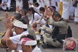 Anggota Brimob yang bertugas di kawasan Gunung Agung turut bersembahyang dalam Upacara Purnama Kapat saat aktivitas Gunung Agung pada level awas di Pura Besakih, Karangasem, Bali, Kamis (5/10). Ritual setahun sekali di Pura yang berjarak sekitar sembilan kilometer dari kawah Gunung Agung tersebut tahun ini juga dijadikan momentum untuk berdoa bersama di seluruh Bali agar terhindar dari bencana gunung meletus. ANTARA FOTO/Hendra/wdy/2017.