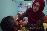 Petugas meneteskan tetes mata pada mata pasien sebelum menjalani operasi katarak saat bakti sosial operasi katarak di Poliklinik Dua Empat Kota Madiun, Jawa Timur, Sabtu (7/10). Bakti sosial operasi katarak yang digelar Tolak Angin Sido Muncul bekerja sama dengan Persatuan Dokter Spesialis Mata Indonesia (Perdami) Cabang Jawa Timur dan Bulan Sabit Merah Indonesia (BSMI) melakukan operasi katarak secara gratis terhadap 50 orang pasien berasal dari sejumlah daerah di Madiun dan sekitar. Antara Jatim/Siswowidodo/uma/17