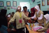Pasien dibimbing keluarganya meninggalkan ruang operasi usai menjalani operasi katarak saat bakti sosial operasi katarak di Poliklinik Dua Empat Kota Madiun, Jawa Timur, Sabtu (7/10). Bakti sosial operasi katarak yang digelar Tolak Angin Sido Muncul bekerja sama dengan Persatuan Dokter Spesialis Mata Indonesia (Perdami) Cabang Jawa Timur dan Bulan Sabit Merah Indonesia (BSMI) melakukan operasi katarak secara gratis terhadap 50 orang pasien berasal dari sejumlah daerah di Madiun dan sekitar. Antara Jatim/Siswowidodo/uma/17
