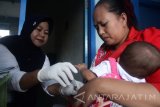 Kader posyandu memberikan imunisasi rubela di Posyandu Kenikir yang menggunakan ruangan dibawah tandon air di Kotalama, Malang, Jawa Timur, Rabu (11/10). Menurut survey yang dilakukan UNICEF, kurangnya infrastruktur posyandu yang memadai dan kesadaran masyarakat yang rendah menjadi hambatan utama bagi keberhasilan program imunisasi campak-rubela di Indonesia sehingga hanya mencapai angka 80-82 persen atau lebih rendah dari sejumlah negara di Asia seperti Thailand dan Maladewa. Antara Jatim/Ari Bowo Sucipto/uma/17.