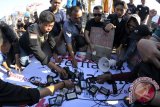 Sejumlah jurnalis melakukan aksi solidaritas untuk wartawan Banyumas, di Tugu Adipura, Bandar Lampung, Lampung, Jumat (13/10/2017). Mereka meminta kepada penegak hukum untuk menindak tegas dan memberi sangki hukum kepada oknum aparat Polisi dan Satpol PP yang terlibat dalam kasus kekerasan terhadap wartawan di Banyumas, Jawa Tengah. (ANTARA FOTO/Ardiansyah)