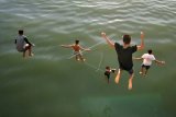 Sejumlah anak meloncat dari jembatan Purus, Padang, Sumatera Barat, Kamis (12/10). Atraksi anak-anak pantai tersebut menjadi daya tarik bagi pengunjung pantai Padang yang terkadang memberikan saweran (uang) kepada mereka. ANTARA FOTO/Iggoy el Fitra/pd/17