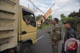 Anggota TNI dan Polisi memeriksa sopir truk yang melintasi kawasan rawan bencana Gunung Agung di Desa Duda Timur, Karangasem, Bali, Sabtu (14/10). Petugas gabungan memasang portal pembatas di sejumlah ruas jalan menuju kawasan rawan bencana menyusul banyaknya warga dan wisatawan yang memasuki daerah berbahaya karena Gunung Agung masih berstatus awas. Antara Bali/Nyoman Budhiana/nym/2017.