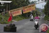 Seorang warga melintasi portal pembatas kawasan rawan bencana Gunung Agung di Desa Duda Timur, Karangasem, Bali, Sabtu (14/10). Petugas gabungan memasang portal pembatas di sejumlah ruas jalan menuju kawasan rawan bencana menyusul banyaknya warga dan wisatawan yang memasuki daerah berbahaya karena Gunung Agung masih berstatus awas. Antara Bali/Nyoman Budhiana/nym/2017.