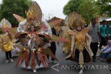 Peserta pawai mengenakan busana karnaval mengikuti pawai budaya di Kota Madiun, Jawa Timur, Minggu (15/10). Ratusan orang peserta mengikuti pawai budaya dalam rangka memeriahkan bersih desa Kelurahan Nambangan Lor Kota Madiun. Antara Jatim/Siswowidodo/uma/17