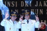 Gubernur DKI Jakarta Anies Baswedan (kanan) dan Wakil Gubernur Sandiaga Uno melakukan salam dua jari dan oke oce di sela serah terima jabatan di Balai Kota DKI Jakarta, Senin (16/10/17). Anies Baswedan dan Sandiaga Uno resmi menjadi Gubernur DKI Jakarta dan Wakil Gubernur untuk periode 2017-2022. (ANTARA FOTO/Sigid Kurniawan).