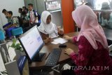 Pelajar mengantre saat penyaluran dana Program Indonesia Pintar (PIP) di Bank BNI Ngawi, Jawa Timur, Kamis (19/10). Kemendikbud mencatat, penyaluran dana PIP yang ditujukan pada 17,92 juta anak se-Indonesia hingga bulan agustus 2017 baru terserap 8,8 juta anak atau sebesar 47 persen dari total target penerima dana PIP. Antara Jatim/Ari Bowo Sucipto/uma/17.