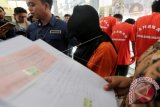 Tersangka calo rekrutmen Pegawai Negeri Sipil (PNS) berinisial S (tengah) dikawal petugas saat gelar perkara di Mapolresta Banda Aceh, Aceh, Kamis (19/10). Tersangka yang bertugas di Biro Humas dan Protokoler Pemerintah Aceh itu melanggar pasal 372 dan Pasal 378 KUHP mengenai penipuan dan penggelapan dengan ancaman hukuman maksimal 4 tahun penjara. (ANTARA FOTO/Irwansyah Putra/Spt/17)