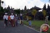 Wisatawan berjalan di Pura Besakih, Kabupaten Karangasem, Bali, Jumat (20/10). Meski sudah ada larangan dari pemerintah, sejumlah warga dan wisatawan tetap nekat bersembahyang ke Pura Besakih yang termasuk dalam radius enam kilometer dari kawah Gunung Agung atau kawasan rawan bencana. ANTARA FOTO/Wira Suryantala/wdys/17.
