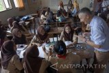 Seorang praktisi pendidikan asal Jerman, Phil Herman Ayen (kanan) memandu diskusi kelompok di kelas jurusan manajemen pariwisata di SMKN 1 Tulungagung, Tulungagung, Jawa Timur, Jumat (20/10). Phil Herman yang berlatar dosen di Jerman ini berkunjung ke Indonesia mewakili lembaga nonprofit SES (Senior Experten Service) dan melakukan studi banding ke sejumlah lembaga pendidikan setingkat SMK sederajat hingga akademi untuk mempelajari sistem pendidikan, kurikulum belajar-mengajar siswa sekaligus memperkenalkan metode pembelajaran ganda (dual system education) berbasis industri (praktik lapangan kerja) dan sekolah (teori). Antara Jatim/Destyan Sujarwoko/uma/17