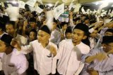 Sejumlah santri mengikuti pembacaan Satu Miliar Sholawat Nariyah di Pondok Pesantren Lirboyo, Kota Kediri, Jawa Timur, Sabtu (21/10) malam. Kegiatan yang dihadiri oleh ribuan santri tersebut untuk memperingati Hari Santri Nasional. ANTARA FOTO/Prasetia Fauzani/pd/17