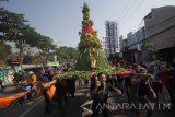 Warga menggotong gunungan berupa sayur dan buah saat mengikuti pawai Sedekah Bumi di Wiyung, Surabaya, Jawa Timur, Minggu (22/10). Sedekah Bumi tersebut merupakan wujud syukur kepada Tuhan atas rezeki dan hasil panen yang melimpah. Antara Jatim/Moch Asim/17.