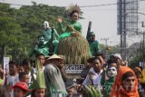 Salah satu peserta memerankan Dewi Sri saat mengikuti pawai Sedekah Bumi di Wiyung, Surabaya, Jawa Timur, Minggu (22/10). Sedekah Bumi tersebut merupakan wujud syukur kepada Tuhan atas rezeki dan hasil panen yang melimpah. Antara Jatim/Moch Asim/17.