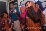 Menteri Sosial Khofifah Indar Parawangsa (tengah) didampingi Direktur Kelembagaan Bank Mandiri Kartini Sally (kiri) dan Direktur Kelembagaan Bank BNI Adi Sulistyowati (dua kanan) mengecek pencairan bantuan sosial Program Keluarga Harapan di anjungan Bank Mandiri di Pondok Pesantren Amanatul Ummah, Pacet, Mojokerto, Jawa Timur, Minggu (22/10). Bank Mandiri terus berkomitmen mendukung implementasi program kerakyatan pemerintah melalui penyaluran bantuan sosial kepada lebih dari 1 juta keluarga senilai Rp1,6 triliun dengan skema Program Keluarga Harapan (PKH) dan program Bantuan Pangan Non Tunai (BNPT) di 23 propinsi di Indonesia. Mandiri juga menurunkan relawan yang berasal dari karyawan terbaik untuk mengoptimalkan penyaluran bansos sekaligus melakukan edukasi keuangan. Antara Jatim/Syaiful Arif/mas/17.