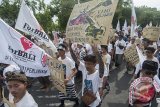 Pengunjuk rasa meneriakkan yel-yel dalam aksi menolak rencana revitalisasi Teluk Benoa, di depan Kantor Gubernur Bali, Denpasar, Selasa (24/10). Ratusan pengunjuk rasa yang tergabung dalam Forum Rakyat Bali Tolak Reklamasi (ForBali) meminta pemerintah untuk membatalkan Perpres 51/2014 dan mendesak Gubernur Bali untuk tidak mengeluarkan izin pelaksanaan reklamasi Teluk Benoa. Antara Bali/Nyoman Budhiana/nym/2017.