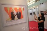 Pengunjung menyaksikan karya foto yang dipajang saat pameran foto Satu Sabuk Satu Jalan yang berlangsung mulai 24-28 Oktober di Surabaya, Jawa Timur, Selasa (24/10). Pameran yang diselenggarakan oleh Konsulat Jenderal (Konjen) Republik Rakyat Cina (RRC) di Surabaya tersebut selain untuk mengenalkan gagasan Satu Sabuk Satu Jalan juga untuk mempererat kerja sama dan rasa pengertian antara pemerintah Cina dan Indonesia. Antara Jatim/Moch Asim/17.