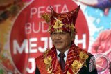 Bupati Karo Terkelin Brahmana mengenakan pakaian adat tradisional suku Karo pada Pesta Budaya Mejuah-Juah di sepanjang jalan utama Brastagi, Kabupaten Karo, Sumatera Utara, Kamis (26/10). Pesta Budaya Karo yang diikuti ribuan masyarakat tersebut, menampilkan tarian dan kesenian budaya suku Karo. ANTARA SUMUT/Septianda Perdana/17