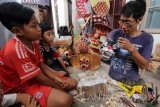 Warga difabel, Mustaq bilal (36), memberikan edukasi pembuatan kerajinan barong kepada anak-anak di Bakungan, Banyuwangi, Jawa Timur, Jumat (27/10). Hasil kerajinan yang dijual seharga Rp200 ribu hingga Rp9 juta tersebut terkendala pemasaran. Antara Jatim/Budi Candra Setya/Uma/17.