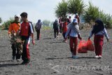 Sejumlah siswa melakukan aksi bersih-bersih pantai dalam memperingati Hari Sumpah Pemuda di Pantai Paseban, Kencong, Jember, Jawa Timur, Sabtu (28/10). Sebanyak 500 siswa-siswi SMK Muhammadiyah 5 Jember melakukan aksi tersebut untuk menjaga kebersihan pantai selatan. Antara Jatim/Seno/uma/17.