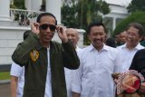 Presiden Joko Widodo (kiri) disaksikan Kepala Staf Kepresidenan Teten Masduki (kedua kiri), Menpora Imam Nahrawi (kedua kanan) dan Menkominfo Rudiantara mencoba kaca mata produk lokal di salah satu stan saat peringatan Hari Sumpah Pemuda ke-89 di Halaman Istana Bogor, Jawa Barat, Sabtu (28/10/2017). Peringatan dengan konsep bernuansa anak muda yang diikuti sekitar 1.000 pemuda berprestasi dari berbagai daerah di Indonesia tersebut mengangkat tema \