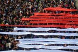 Sejumlah dosen dan mahasiswa mengibarkan bendera merah putih saat peringatan Hari Sumpah Pemuda di halaman kampus Universitas Surabaya, Surabaya, Jawa Timur, Sabtu (28/10). Kegiatan yang melibatkan ribuan mahasiswa dengan menggunakan pakaian adat tersebut sebagai momentum untuk menunjukkan berbeda latar belakang, budaya, agama, etnis, tapi tetap satu kesatuan. Antara Jatim/Umarul Faruq/uma/17