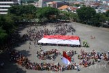 Sejumlah dosen dan mahasiswa membentuk formasi delapan pulau Indonesia dan mengibarkan bendera merah putih saat peringatan Hari Sumpah Pemuda di halaman kampus Universitas Surabaya, Surabaya, Jawa Timur, Sabtu (28/10). Kegiatan yang melibatkan ribuan mahasiswa dengan menggunakan pakaian adat tersebut sebagai momentum untuk menunjukkan berbeda latar belakang, budaya, agama, etnis, tapi tetap satu kesatuan. Antara Jatim/Umarul Faruq/uma/17