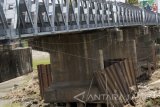 Kondisi fondasi jembatan yang rusak dan menggantung memperlihatkan tiang pancang (pasak bumi) di bawah Jembatan Ngujang, Tulungagung, Jawa Timur, Minggu (29/10). Fondasi jembatan penghubung jalan nasional Tulungagung-Kediri-Blitar sepanjang 100 meter itu rusak berat tergerus erosi aliran Sungai Brantas, diduga akibat faktor usia serta aktivitas penambangan pasir mekanik secara ilegal dan masif sehingga memicu munculnya palung-palung sungai. Antara Jatim/Destyan Sujarwoko/uma/17