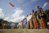 Sejumlah pemuda memakai pakaian adat saat mengikuti upacara bendera di Pulau Bawean, Gresik, Jawa Timur, Sabtu (28/10). Upacara dengan pakaian adat tersebut dalam rangka memperingati Hari Sumpah Pemuda. Antara Jatim/Moch Asim/17.