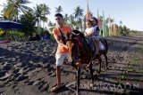 Wisatawan menaiki kuda yang disewakan di pantai Cacalan, Banyuwangi, Jawa Timur, Sabtu (28/10). Wisata berkuda yang disewakan seharga Rp10 ribu sekali putaran itu menjadi salah satu destinasi yang menjadi daya tarik wisatawan. Antara Jatim/Budi Candra Setya/mas/17.