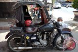 Pengemudi becak memeriksa kondisi becak motornya, di Pematang Siantar, Sumatera Utara, Minggu (29/10). Becak yang digerakkan dengan motor Birmingham Small Arms (BSA) tersebut adalah kendaraan sisa perang dunia kedua dan menjadi alat transportasi khas Kota Pematang Siantar. ANTARA SUMUT/Irsan Mulyadi/17