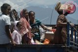 Warga berada di atas truk dengan latar belakang Gunung Agung saat akan meninggalkan posko pengungsian di wilayah Sukahat, Lokasari, Karangasem, Bali, Senin (30/10). Sebagian pengungsi Gunung Agung mulai dipulangkan secara bertahap menyusul diturunkannya status Gunung Agung dari level IV (Awas) menjadi level III (Siaga) pada Minggu (29/10). ANTARA FOTO/Fikri Yusuf/wdy/2017.