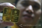 Karyawan menunjukkan emas batangan  yang penjualannya kini menurun di sebuah gerai pusat penjualan emas di Malang, Jawa Timur, Senin (30/10). Fluktuasi harga emas dalam dua pekan terakhir yang dinilai masih cukup tinggi yakni berada di kisaran harga Rp555.000 per gram untuk jenis emas lokal membuat penjualan emas di kawasan tersebut turun hingga 40 persen terutama jenis emas batangan. Antara Jatim/Ari Bowo Sucipto/mas/17. 