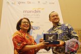 Direktur Mandiri Sekuritas Lisana Irianiwati (kiri) memberikan cinderamata kepada Direktur Pengembangan Bursa Efek Indonesia, Nicky Hogan (kanan) saat membuka Kegiatan Edukasi Pasar Modal di Singkawang, Kalbar, Rabu (1/11). Mandiri Sekuritas yang memiliki lebih dari 72 ribu nasabah yang menggunakan layanan multiplatform Mandiri Online Securities Trading (MOST) tersebut, merupakan perusahaan anggota bursa pertama yang melakukan edukasi hingga ke perbatasan Indonesia-Malaysia yaitu Kecamatan Paloh dan Aruk di Kabupaten Sambas, Kalbar. ANTARA FOTO/Jessica Helena Wuysang/17