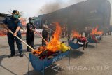 Petugas membakar sejumlah barang bukti bersifat 'personal effect' saat pemusnahan barang bukti Kantor Pengawasan dan Pelayanan Bea dan Cukai Tipe Madya Pabean Tanjung Perak (KPP BC Tanjung Perak) di Surabaya, Jawa Timur, Rabu (1/11). KPP BC Tanjung Perak memusnahkan barang bukti impor ilegal yaitu 15.360 botol minuman keras merk Red Label, 10.680 botol berbagai ukuran merk Aquilla Mineral water dan sejumlah barang bukti bersifat 'personal effect' lainnya. Antara Jatim/Didik Suhartono/uma/17