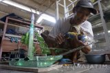 Perajin menyelesaikan pembuatan miniatur menyerupai bentuk kapal berbahan limbah kaca di Tulungagung, Jawa Timur, Kamis (2/11). Miniatur limbah kaca untuk interior rumah/kantor yang dilengkapi lampu hias itu dijual seharga Rp100 ribu hingga Rp300 ribu per buah, menyesuaikan ukuran dan tingkat kesulitan pembuatan. Antara Jatim/Destyan Sujarwoko/mas/17.