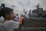 Sejumlah anak melambaikan bendera menyambut kedatangan kapal perang Korea Selatan Hwacheon (AOE-59) saat bersandar di Dermaga Jamrud Utara, Pelabuhan Tanjung Perak, Surabaya, Jawa Timur, Minggu (5/11). Kedatangan dua kapal perang Korea Selatan Kang Gam Chan (DDH-II), Hwacheon (AOE-59) beserta 630 taruna AAL Korea Selatan tersebut merupakan rangkaian dari kegiatan pelatihan dan praktek pelayaran dalam program 'Republic of Korea (ROK) Navy Cruise Training' 2017. Antara Jatim/Moch Asim/17.