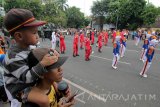 Warga menyaksikan Parade Surabaya Juang 2017 di Jalan Gubernur Suryo, Surabaya, Jawa Timur, Minggu (5/11). Parade yang diikuti ribuan peserta itu dalam rangka memperingati Hari Pahlawan. Antara Jatim/Didik Suhartono/mas/17.