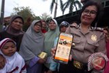 Wakapolsek Medan Sunggal AKP Artha Sebayang memperlihatkan aplikasi "Polisi Kita" saat melakukan sosialisasi kepada masyarakat di Jalan Beo Medan, Sumatera Utara, Senin (6/11). Aplikasi berbasis android "Polisi Kita" tersebut untuk memudahkan masyarakat melaporkan ketika terjadi berbagai tindak kejahatan. ANTARA SUMUT/Septianda Perdana/17