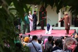 Terpidana (duduk) pelanggar peraturan daerah (qanun) syariat Islam menjalani eksekusi hukuman cambuk di Kuta Alam, Banda Aceh, Aceh, Selasa (7/11). Mahkamah Syar'iah Kota Banda Aceh memvonis hukuman 22 kali cambuk di muka umum kepada dua terpidana pelanggar qanun Jinayat nomor 6/2014 tentang ikhtilat (bercumbu mesra tanpa ikatan nikah). (ANTARA FOTO/Irwansyah Putra/ama/17)