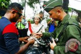 Petugas Polisi Lalu lintas Polres Metropolitan Tangerang memeriksa surat kendaraan pada operasi Zebra Jaya 2017 dengan menggunakan pakaian ala pejuang di Jalan Ahmad Yani, Tangerang, Banten, Jumat (10/11). Penggunaan pakian ala pejuang dilakukan satuan Polantas Tangerang dalam rangka memperingati Hari Pahlawan 2017. ANTARA FOTO/Muhammad Iqbal/wdy/2017