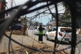Pengguna jalan berhati-hati saat melintas di samping jaringan kabel sejumlah provider layanan internet yang dibiarkan kusut dan semrawut di Jalan Borobudur, Malang, Jawa Timur, Minggu (12/11). Belum ada penanganan dari pemerintah setempat meski kondisi yang membahayakan bagi pengguna jalan tersebut sudah berlangsung selama hampir dua bulan. Antara Jatim/Ari Bowo Sucipto/uma/17.