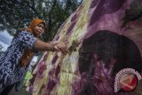 Pengrajin melepas daun yang menempel pada kain saat proses pembuatan kain Ecoprint di Industri Rumahan Ecoprint Kaine, Nogotirto, Gamping, Sleman, DI Yogyakarta, Selasa (14/11). Kain olahan berbasis pewarna alam yang dipasarkan ke sejumlah daerah seperti Jakarta, Bali dan Yogyakarta itu dipatok dengan harga antara Rp 100.000 hingga Rp. 400.000 per lembar tergantung kualitas. ANTARA FOTO/Andreas Fitri Atmoko/wdy/2017.