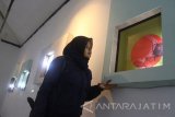 Seorang pengunjung melihat lukisan dalam Pameran Tunggal karya Seniman Yudho Tri Wahyudi yang bertajuk 'Over Warm' di Gedung DKM, Malang, Jawa Timur, Selasa (14/11). Pameran yang berlangsung selama delapan hari tersebut menampilkan 20 karya lukisan yang dikemas dalam seni instalasi sebagai ungkapan kritik sosial tentang pesatnya pembangunan yang dinilai j menyisakan beberapa masalah seperti penggusuran dan pencemaran lingkungan. Antara Jatim/Ari Bowo Sucipto/mas/17.