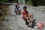 Sejumlah anak meluncur di jalan menggunakan mainan 'rodaroda' di dusun Salena, Tipo, Palu, Sulawesi Tengah, Rabu (15/11). Anak-anak di wilayah terpencil itu masih menggunakan permainan tradisional rodaroda yang terbuat dari kayu dan dibentuk menyerupai sepeda motor untuk bermain. ANTARAFOTO/Basri Marzuki/wdy/2017