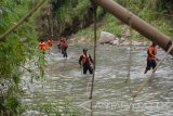 Petugas Badan Penanggulangan Bencana Derah (BPBD) Magetan bersama relawan melakukan pencarian korban banjir di Magetan, Jawa Timur, Sabtu (18/11). Tim gabungan BPBD, Basarnas dan relawan selama tiga hari sejak Kamis (16/11) melakukan penyisiran gorong gorong dan sungai untuk mencari Fabustam Abu Amar pelajar SMA yang hanyut terseret arus air saat bermain bersama Arega Rafasta Fifa yang jenazahnya sudah ditemukan Kamis (16/11). Antara Jatim/Siswowidodo/mas/17.