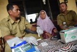 Petugas Dinas Kesehatan Surabaya mengambil darah dari warga untuk diperiksa di Kawasan Wiyung Surabaya, Jawa Timur, Selasa (21/11). Pemeriksaan darah tersebut terkait adanya salah satu warga meninggal dunia yang diduga terjangkit virus tikus atau leptospirosis. Antara Jatim/M Risyal Hidayat/mas/17.