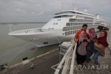 Sejumlah warga berswafoto dengan latar belakang kapal pesiar Silver Shadow yang bersandar di Dermaga Jamrud Utara, Gapura Surya Nusantara, Pelabuhan Tanjung Perak, Surabaya, Jawa Timur, Selasa (21/11). Kapal pesiar itu mengangkut ratusan wisatawan asing yang berkunjung ke sejumlah tempat wisata di Kota Surabaya. Antara Jatim/Didik Suhartono/mas/17.