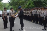 Kapolda Jawa Timur Irjen Pol Machfud Arifin Brigadir (kedua kiri) menyerahkan piagam penghargaan kepada personel Brimob Den C Pelopor Satbrimob Polda Jawa Timur Brigadir Rochmat Tri Marwoto (ketiga kiri) di Desa Klagen Serut, Jiwan, Kabupaten Madiun, Selasa (21/11). Rochmat dinilai memiliki kepedulian sosial cukup tinggi antara lain mengangkat 64 anak yatim dan tidak mampu menjadi anak asuh yang ditampung di panti asuhan pribadi, bedah rumah warga tidak mampu serta merawat warga yang sakit hingga sembuh. Antara Jatim/Siswowidodo/mas/17.